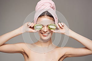 woman with a towel on her head clean skin kiwi in hand cropped view