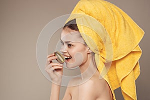 woman with a towel on her head skin care kiwi in hand cropped view