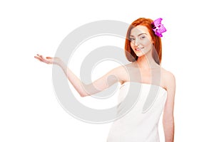 Woman in towel smiling holding somthing in hand