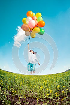 Woman with toy balloons in spring field