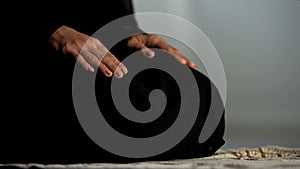 Woman in traditional black hijab kneeling on prayer mat mosque, islamic culture