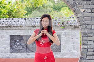 Woman in traditional Cheongsam welcoming guess during Chinese new year