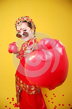 Woman in traditional Chinese costume and boxing gloves