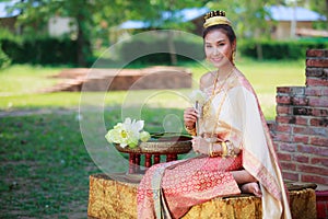 Woman in traditional clothes fold lotus flower petals used in rituals of Buddhism religion. A Lotus represents purity of body