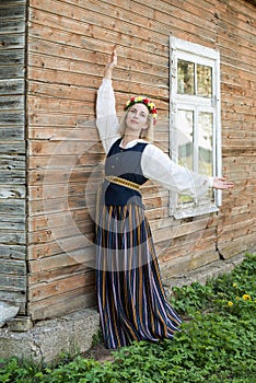 Woman in traditional clothing posing on nature in village.