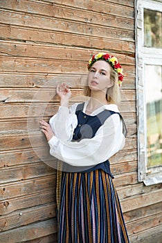 Woman in traditional clothing posing on nature in village.