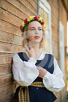 Woman in traditional clothing posing on nature in village.