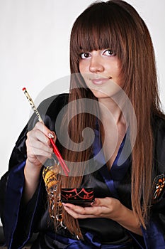 Woman in traditional dress with sushi earthenware,