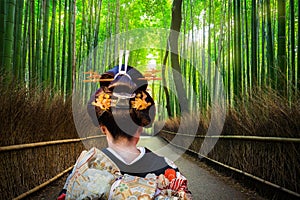 Woman in traditional kimono walking at bamboo forest of Arashiyama, Japan