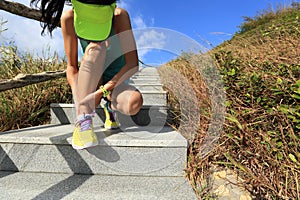 Woman trail runner hold her sports injured ankle