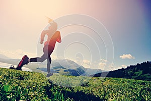 Woman trail runner running on beautiful mountain peak