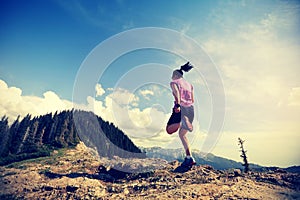 Woman trail runner running on beautiful mountain peak