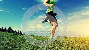 Woman trail runner running on beautiful mountain peak