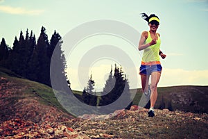 woman trail runner running on beautiful mountain peak