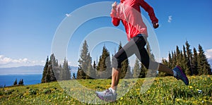 Woman trail runner running on beautiful mountain peak