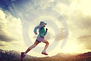 woman trail runner running on beautiful mountain peak