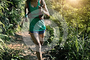 woman trail runner running in morning forest