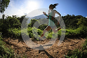Woman trail runner running in morning forest