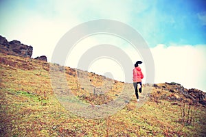 Woman trail runner running on mountain peak