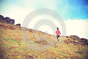 Woman trail runner running on mountain peak