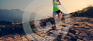 Woman trail runner running at mountain top