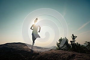 Woman trail runner running at mountain top