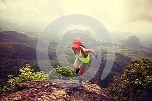 Woman trail runner running at mountain top