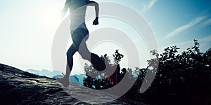Woman trail runner running to mountain top