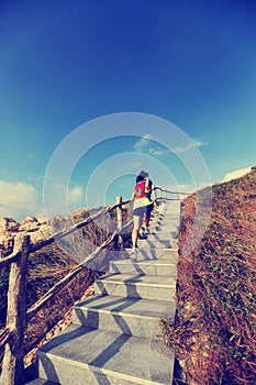 Woman trail runner running up on mountain stairs