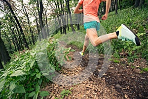 Woman trail running in green forest. Endurance sport.