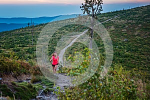 Woman trail running in mountains.