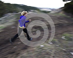 Woman trail running in mountains