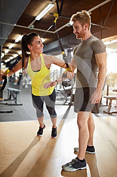 Woman train in gym with trainer assisting