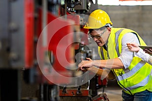 Woman trainee and engineer man wearing safety goggles and hardhat helmet working at Metal lathe industrial manufacturing factory