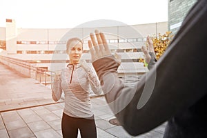 Woman with trainer working out self defense strike