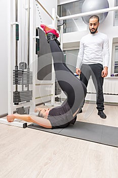 Woman training abdominals on cable machine at gym