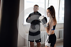 Woman training boxing with personal trainer. Instructor teaching female boxer fighting practice together