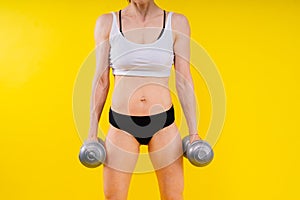 Woman training with dumbbells, pumping up muscles of hands and legs.