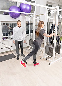 Woman training at gym using cable machine