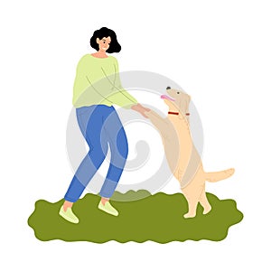 Woman training her dog and holding paws outdoor during walk