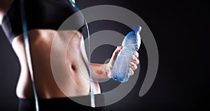 Woman after training holding water bottle