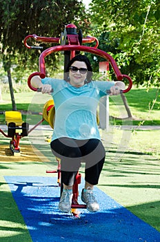 Woman training on a Lat Pull fitness machine outdoor