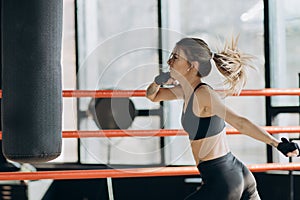 Woman training punching bag in fitness studio fierce strength fit body