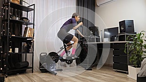 Woman is training on static bike. Indoor exercise workout. Cycling indoor