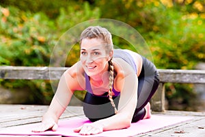 Woman training yoga outdoor in autumn