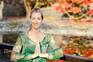 Woman training yoga outdoor in autumn park