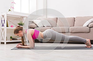 Woman training yoga in plank pose.