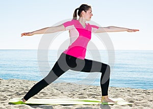 Woman training yoga poses on beach