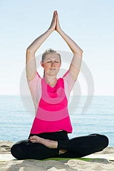 Woman training yoga poses on beach