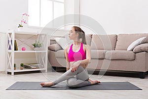 Woman training yoga in twisting sage pose.